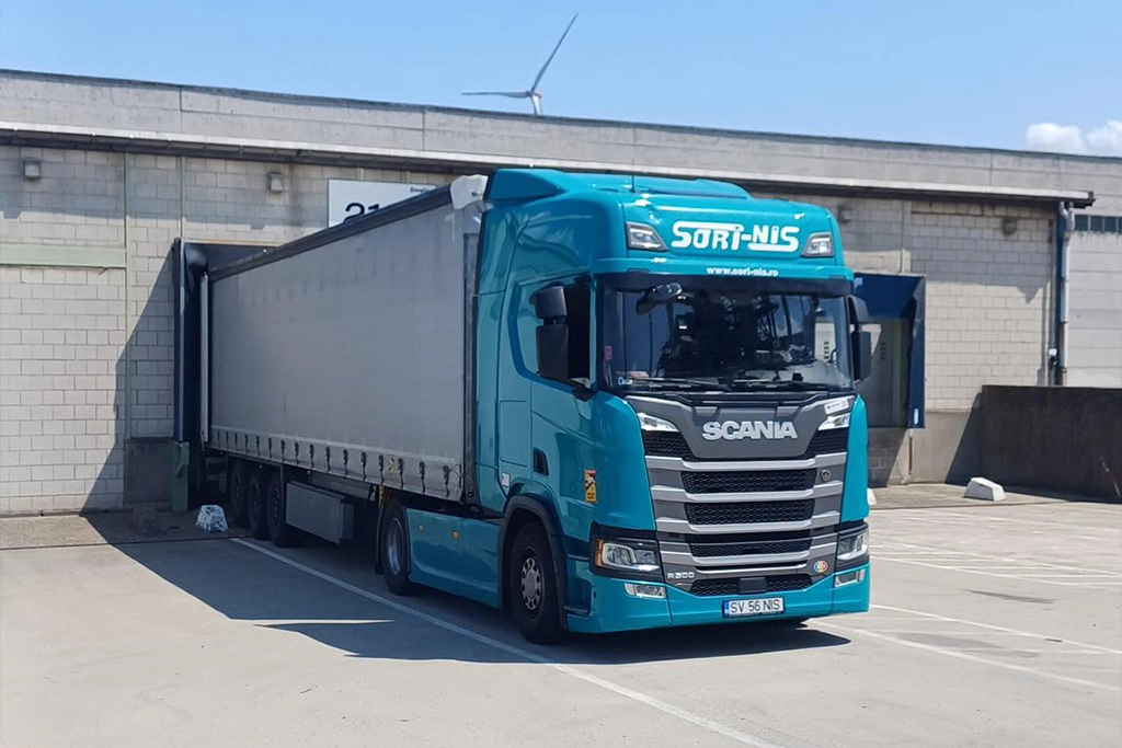 Camion Scania si semiremorca cu prelata asteptand in rampa la incarcare