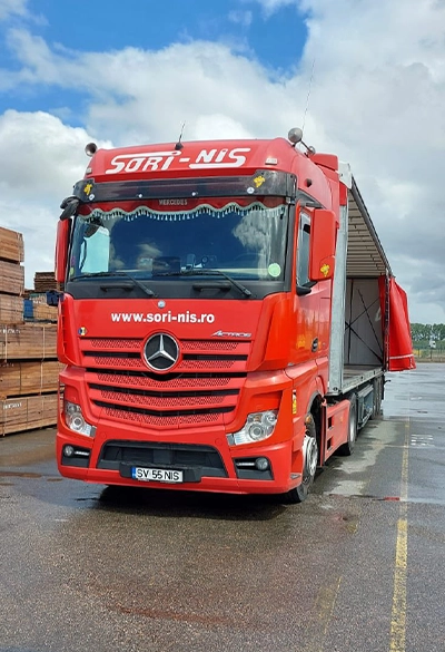 Camion Mercedes-Benz rosu si semiremorca pentru transport marfuri generale in Europa